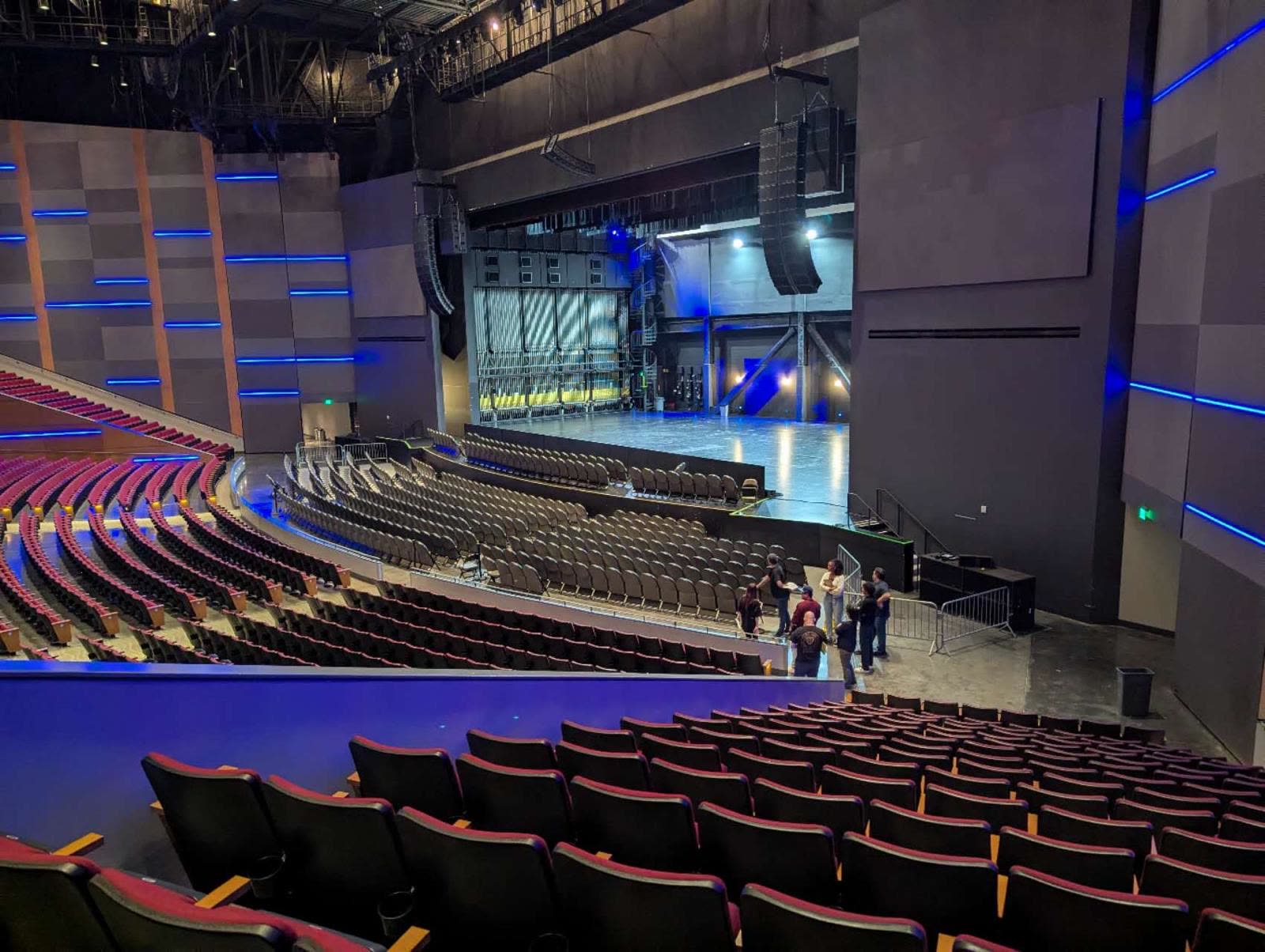 An empty theatre before doors, line arrays flown either side.