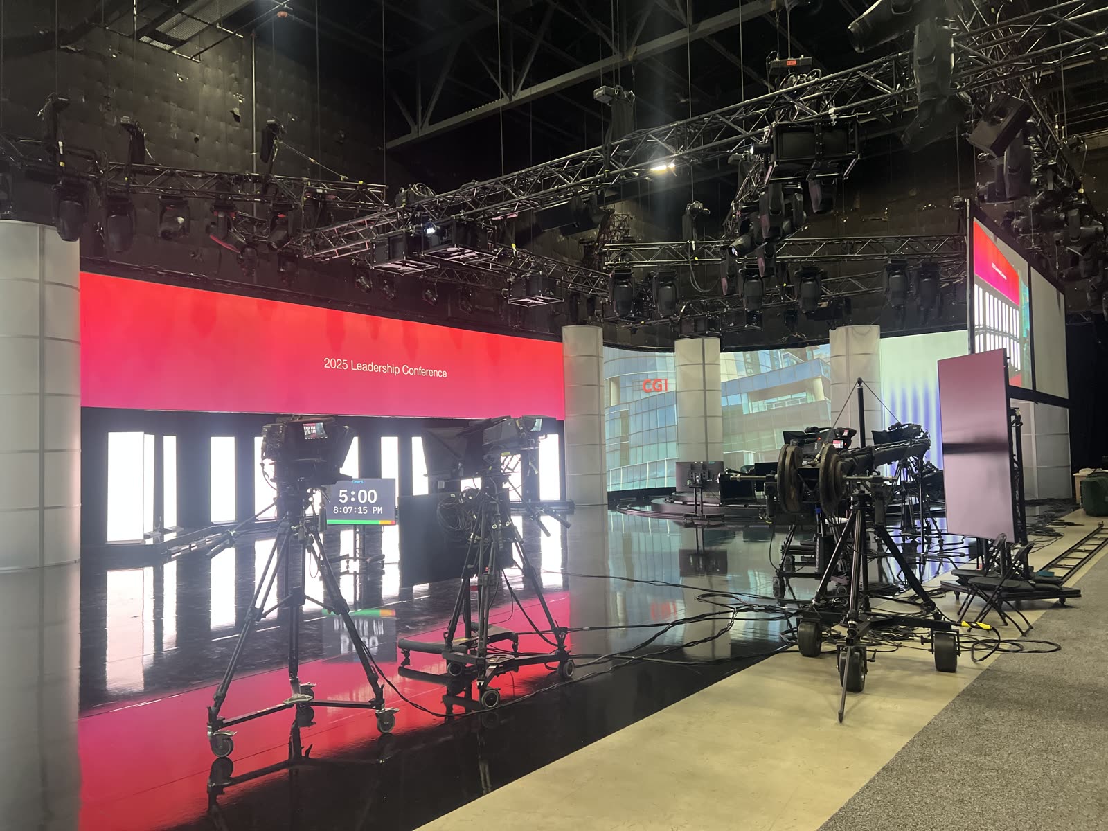 Broadcast-style conference set: cameras, a jib and the LED wall behind.